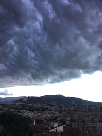 Buildings in town against cloudy sky