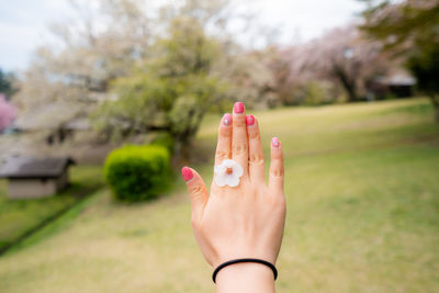 Cropped hand of woman holding flower