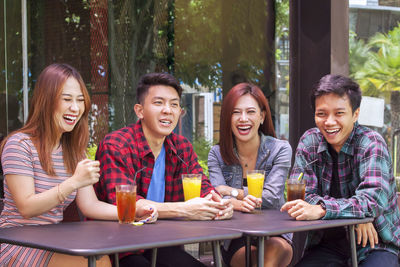 Young couple sitting on table at outdoor cafe