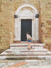 Full length of woman walking on staircase against building