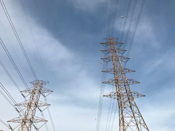 Low angle view of electricity pylon against sky