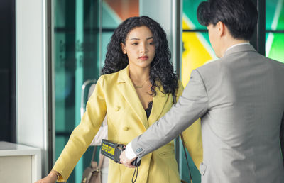 Side view of young woman standing in office