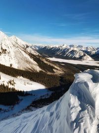 Scenic view of snowcapped mountains against blue sky