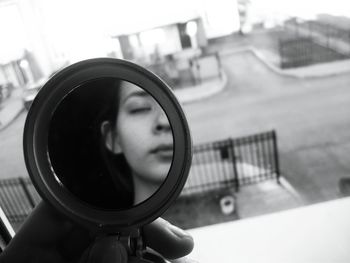 Close-up portrait of young woman holding camera