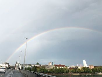 Rainbow over city against sky