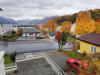 Trees and houses against sky during autumn