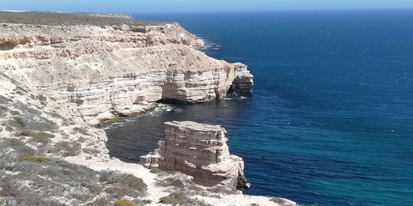 High angle view of rock formation in sea against sky