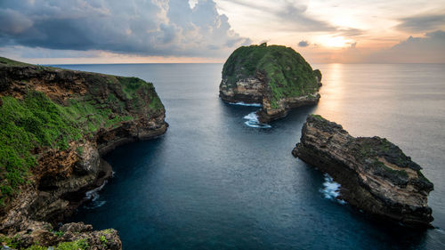 Rock formations in sea against sky