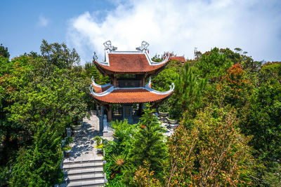 Temple amidst trees and building against sky