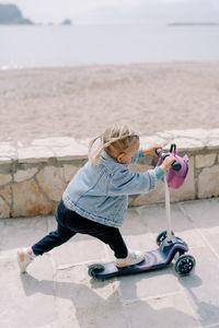 Full length of boy playing with ball at beach