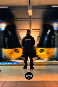 Rear view of man standing at subway station