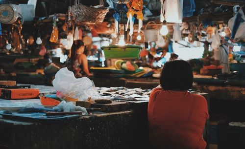 Rear view of woman at market during night