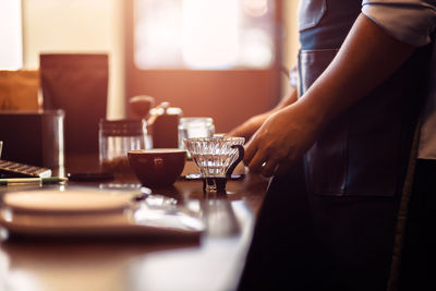 Midsection of barista making coffee at cafe