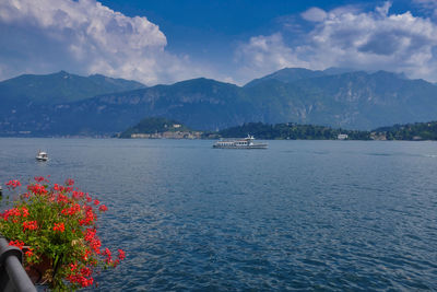 Scenic view of sea by mountains against sky