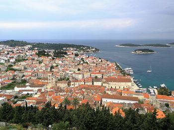 High angle view of townscape by sea against sky