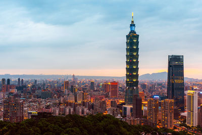 Modern buildings in city against cloudy sky