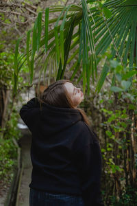 Rear view of woman standing against plants
