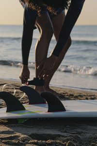 Surfer preparing to surf on the beach at sunrise person