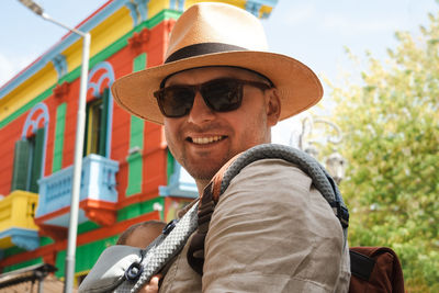 Happy man, father carrying little newborn baby in carrier ,family traveling in buenos aires