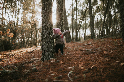 Baby girl standing in forest during sunset