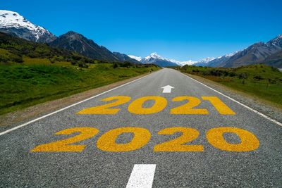 Text on road by mountain against blue sky