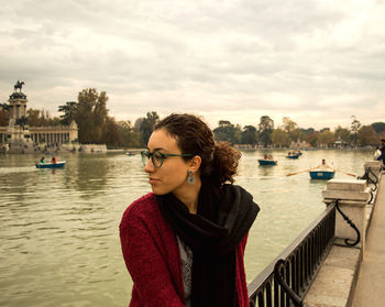 Young woman on lakeside against sky