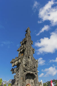 Low angle view of cross on building against sky