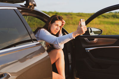 Side view of woman sitting in car