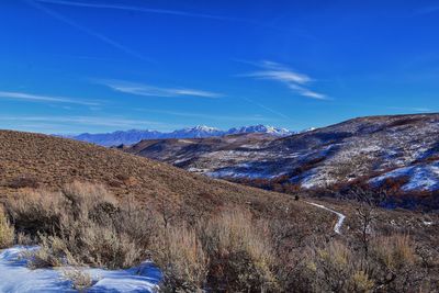 Scenic view of mountains against blue sky