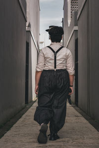 Rear view of woman standing against building