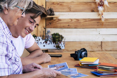 Senior woman with grandson looking photographs on table at home