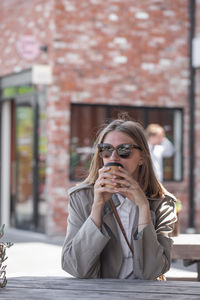Portrait of young woman using mobile phone in cafe