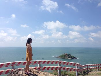 Side view of woman looking at sea against sky