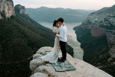 Man standing on rock looking at mountains