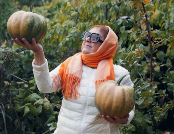 Portrait of young woman holding pumpkin