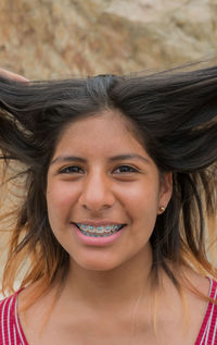 Close-up portrait of smiling young woman wearing braces