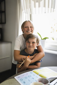 Portrait of smiling sibling in living room at home