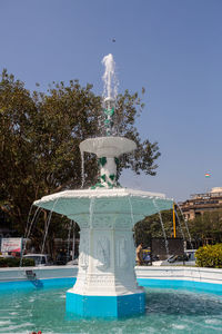 Fountain in swimming pool against clear blue sky