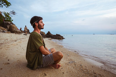 Young man sitting on beach