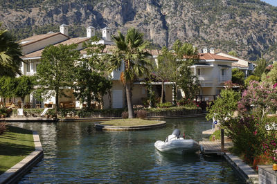 Canal by houses against mountains