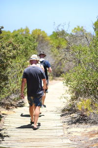 Rear view of couple walking on footpath