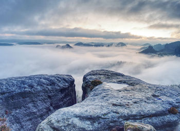 Beautiful sunrise cloudy sky with silhouette hills and cliff in the morning on mountain summit.