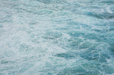 Sea water surface with white foam. natural texture, blue ocean, turquoise.