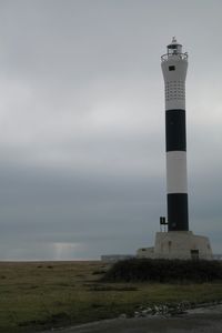 Lighthouse on sea against sky