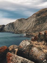 Rock formations by sea against sky