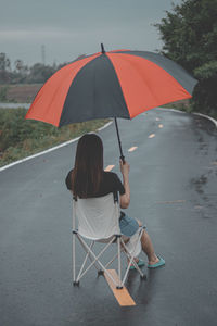 Rear view of woman with umbrella on beach