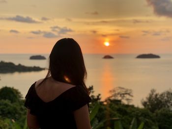 Rear view of woman looking at sunset