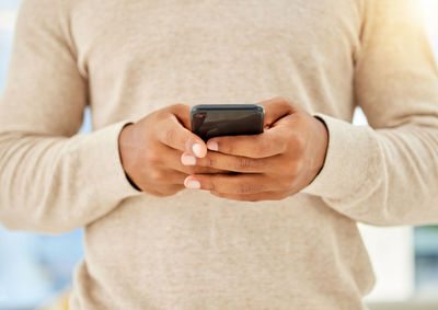 Midsection of man using mobile phone