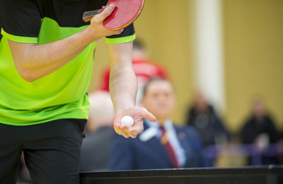 Midsection of player holding table tennis racket