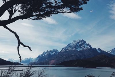 Scenic view of lake by snow mountains against sky